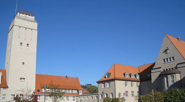 Sonniger Rathausplatz in Delmenhorst mit Rathaus, Wasserturm und Blumenbeeten