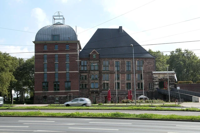 Schloss Horst in Gelsenkirchen mit grünen Freiflächen und Straßenbahntrasse
