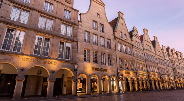 Historische Giebelhäuser und beleuchtete Arkaden am Prinzipalmarkt in Münster