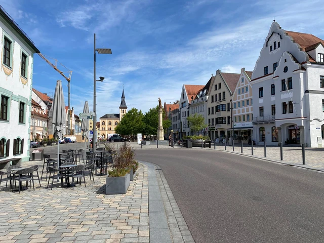 Hauptplatz in Pfaffenhofen an der Ilm mit Häusern, Cafétischen und blauem Himmel