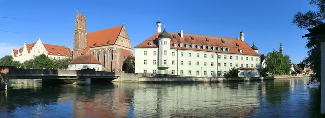 Historische Häuser und Kirchturm von Landshut an der Isar unter blauem Himmel