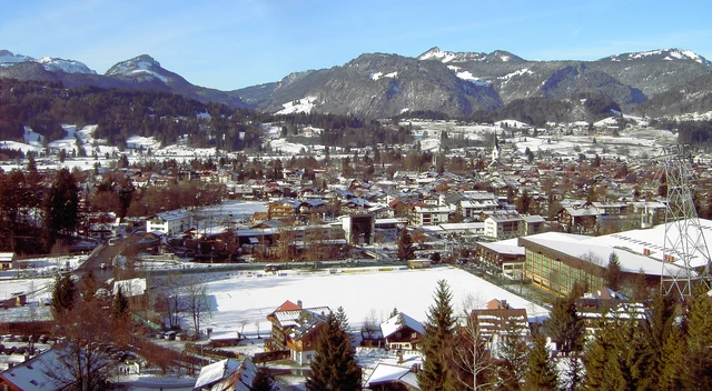 Schneebedeckte Wiesen und Dächer in Oberstdorf vor den Allgäuer Bergen