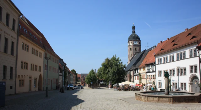 Sonniger Marktplatz von Sangerhausen mit Kirche, historischen Häusern und Straßencafés im Landkreis Mansfeld-Südharz